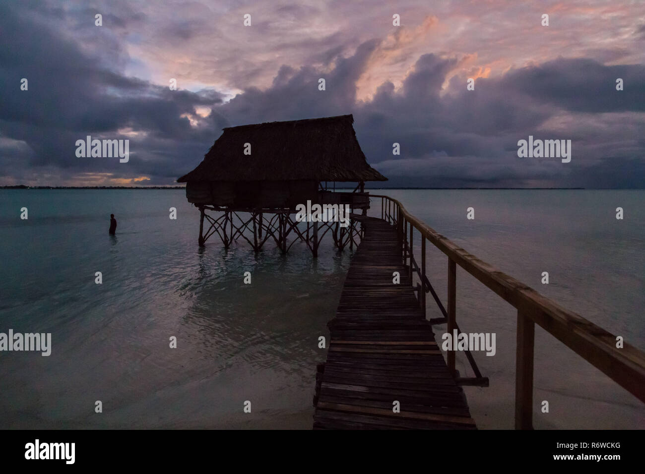 Traditionelle Overwater Bungalow strohgedeckten Hütte in der Lagune von South Tarawa Atolls, Nacht, Abend, Dämmerung, Sonnenuntergang, Kiribati, Mikronesien, Ozeanien. Stockfoto