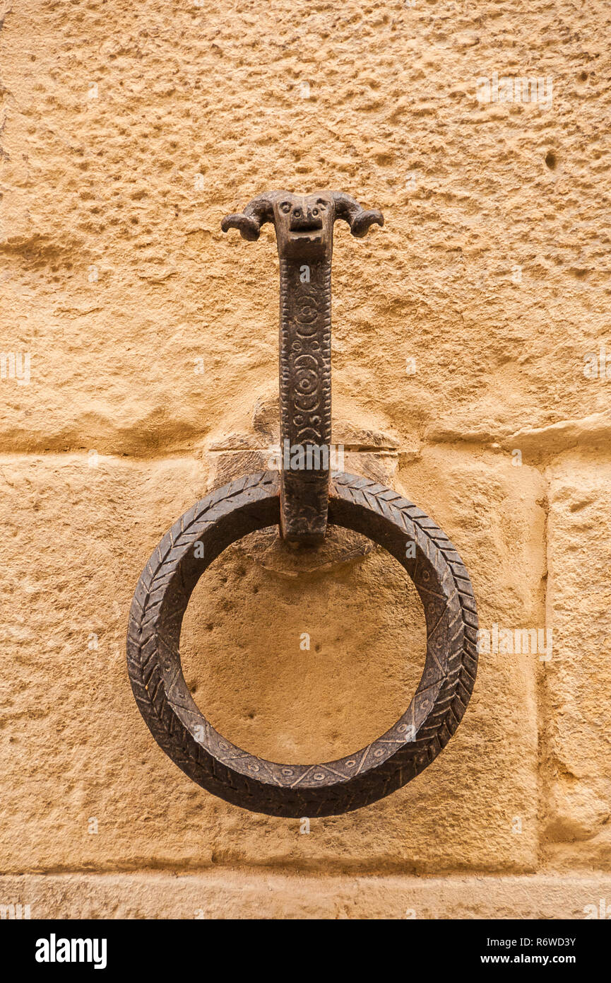 Alten schmiedeeisernen Ring für Tethering Pferde mit RAM-Kopf, auf einem Block Stein Wand Stockfoto