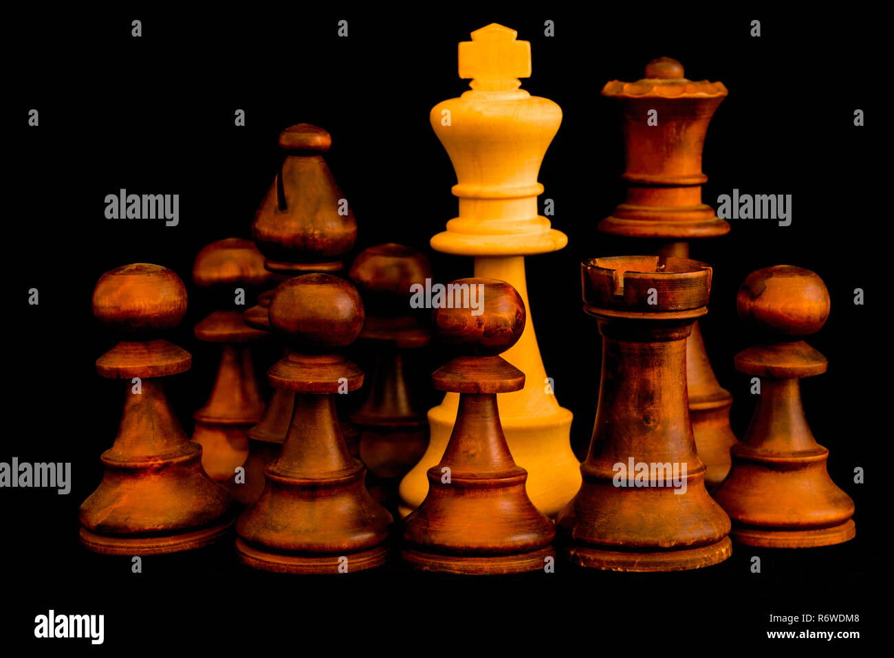 Unter Belagerung. Weiße König von schwarzen Feinde mit Sinn für kein Entrinnen, Standard Schach Holzstück auf schwarzem Hintergrund Stockfoto
