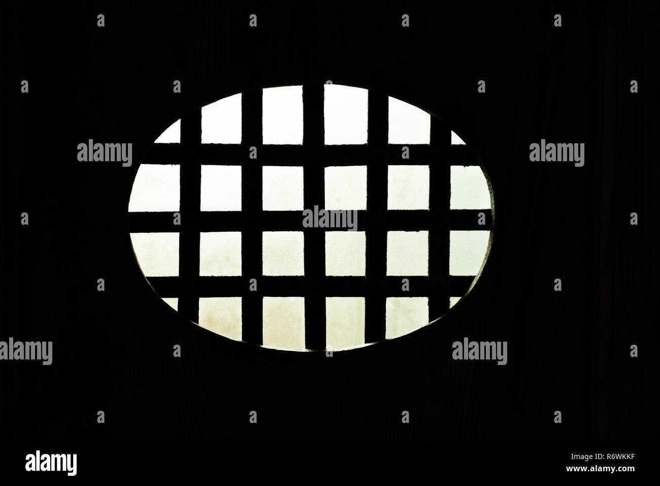 Photosyn aus den dunklen Innenraum eines oval Metallgitter mit der beleuchteten Fassade Stockfoto