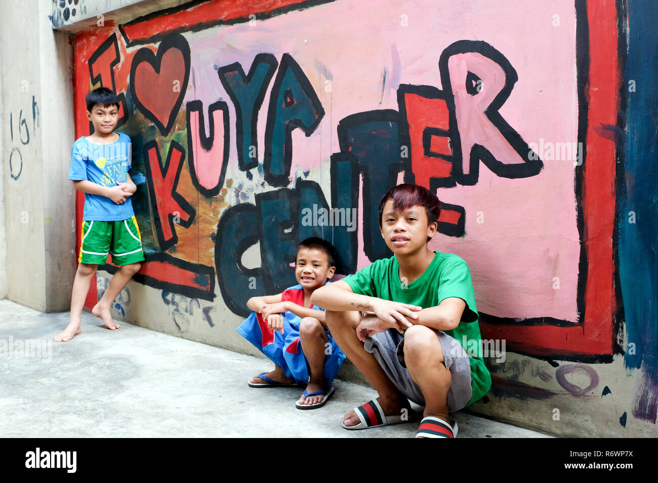 Street Kids Kinder vor einem Graffiti Wand an der Kuya Zentrum für Straßenkinder in Quezon City, Metro Manila, Philippinen. Stockfoto