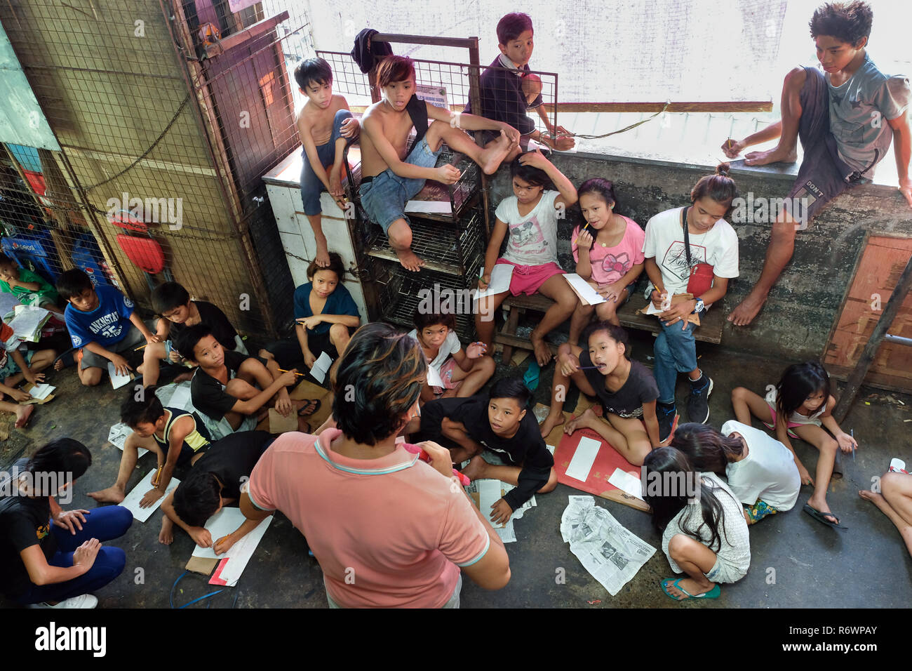 Sozialarbeiter des Kuya Zentrum für Straßenkinder in Kontakt kommen mit heimatlosen Kindern auf einem Markt in Quezon City, Metro Manila, Philippinen zu registrieren. Stockfoto