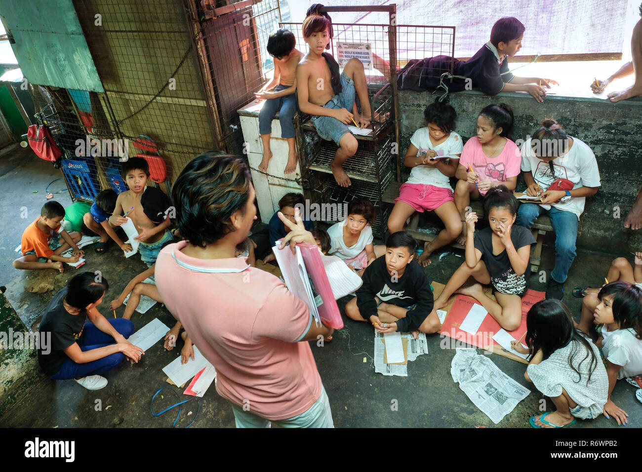 Sozialarbeiter des Kuya Zentrum für Straßenkinder in Kontakt kommen mit heimatlosen Kindern auf einem Markt in Quezon City, Metro Manila, Philippinen zu registrieren. Stockfoto