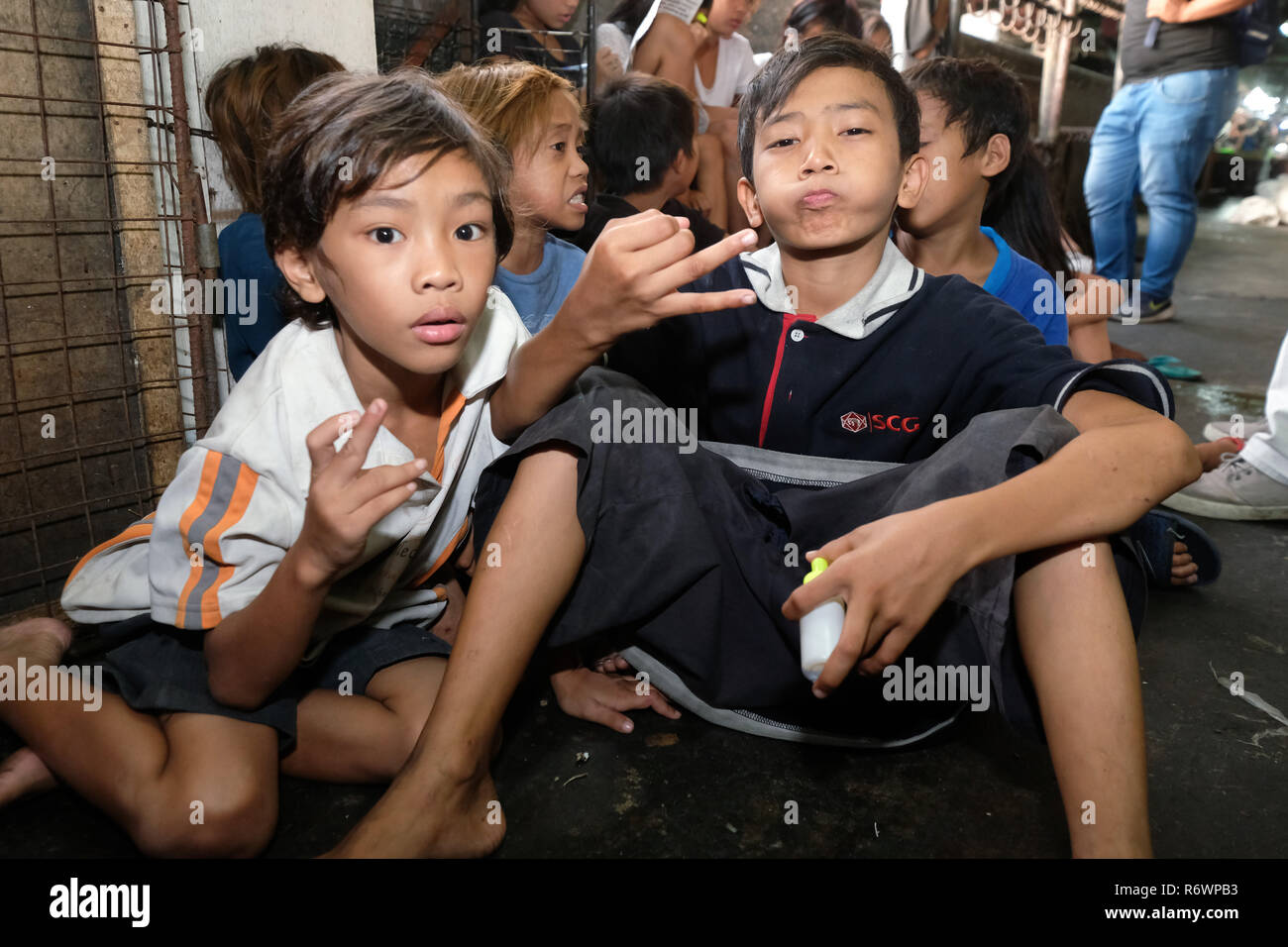 Sozialarbeiter des Kuya Zentrum für Straßenkinder in Kontakt kommen mit heimatlosen Kindern auf einem Markt in Quezon City, Metro Manila, Philippinen zu registrieren. Stockfoto