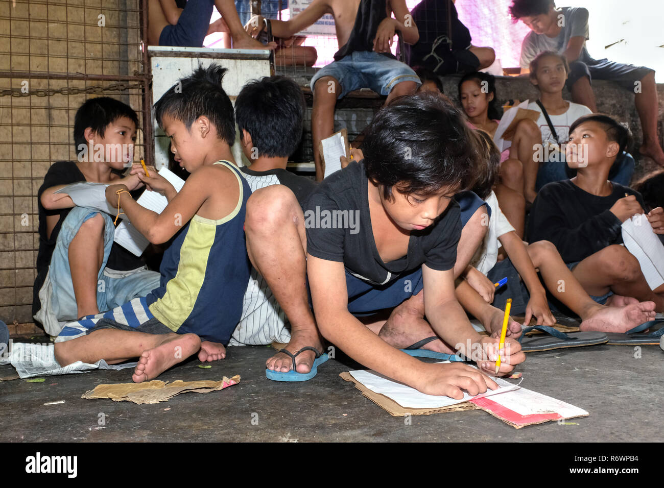 Sozialarbeiter des Kuya Zentrum für Straßenkinder in Kontakt kommen mit heimatlosen Kindern auf einem Markt in Quezon City, Metro Manila, Philippinen zu registrieren. Stockfoto