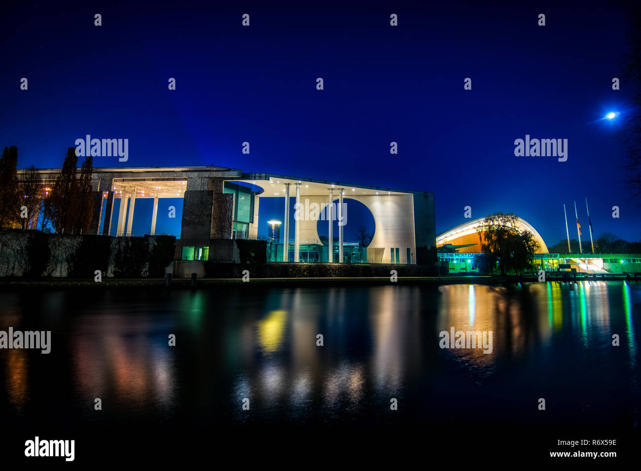 Night Shot der Bundeskanzler Amt (Bundeskanzleramt) und das Haus der Kulturen von der Spree mit Reflexionen auf dem Wasser gesehen Stockfoto