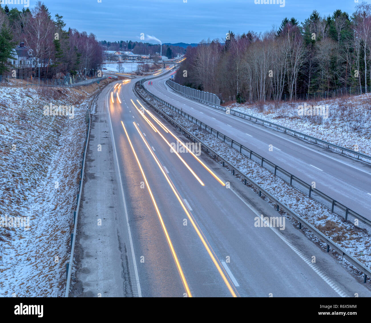 Am frühen Morgen im Berufsverkehr durch frostigen Landschaft Langzeitbelichtung mit Scheinwerfer Lichterkette Stockfoto