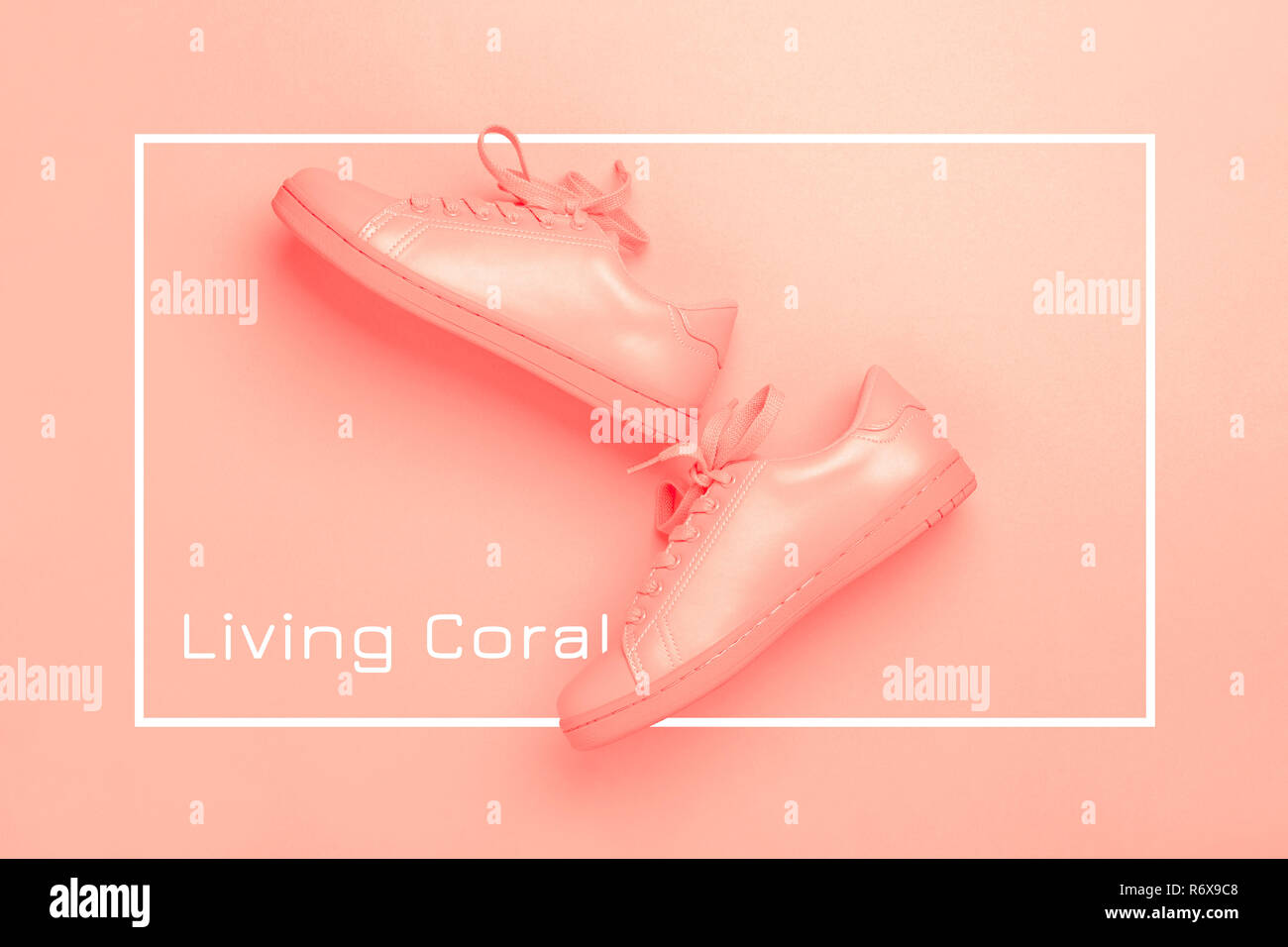 Paar coral Schuhe auf Coral Hintergrund. Trendy lebende Koralle Farbe des Jahres 2019. Schwarzweißbild. Stockfoto