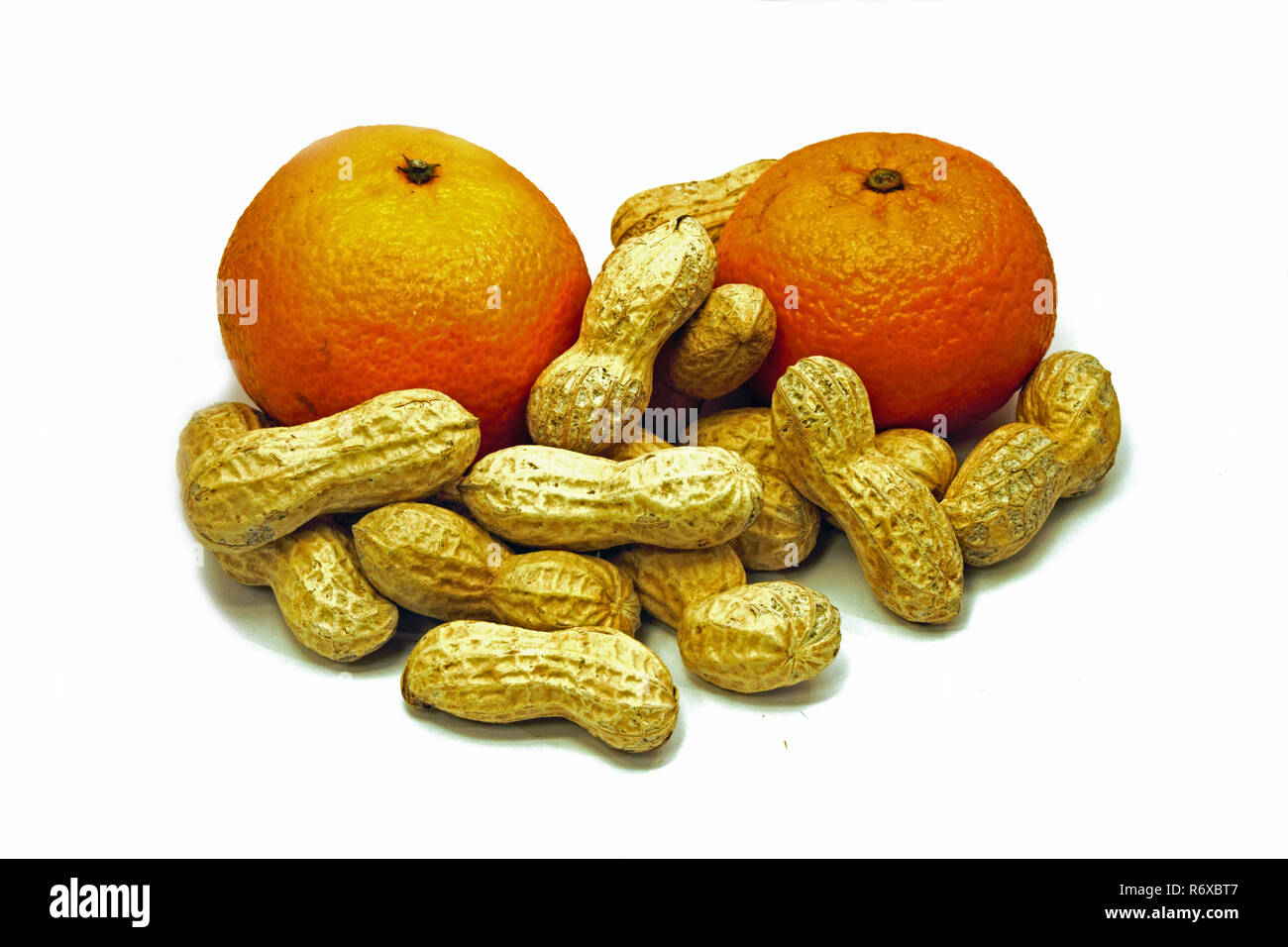 Erdnüsse und Mandarinen sind eine traditionelle Sankt Nikolaus Snack in einigen europäischen Ländern. Auf weissem Hintergrund. Stockfoto