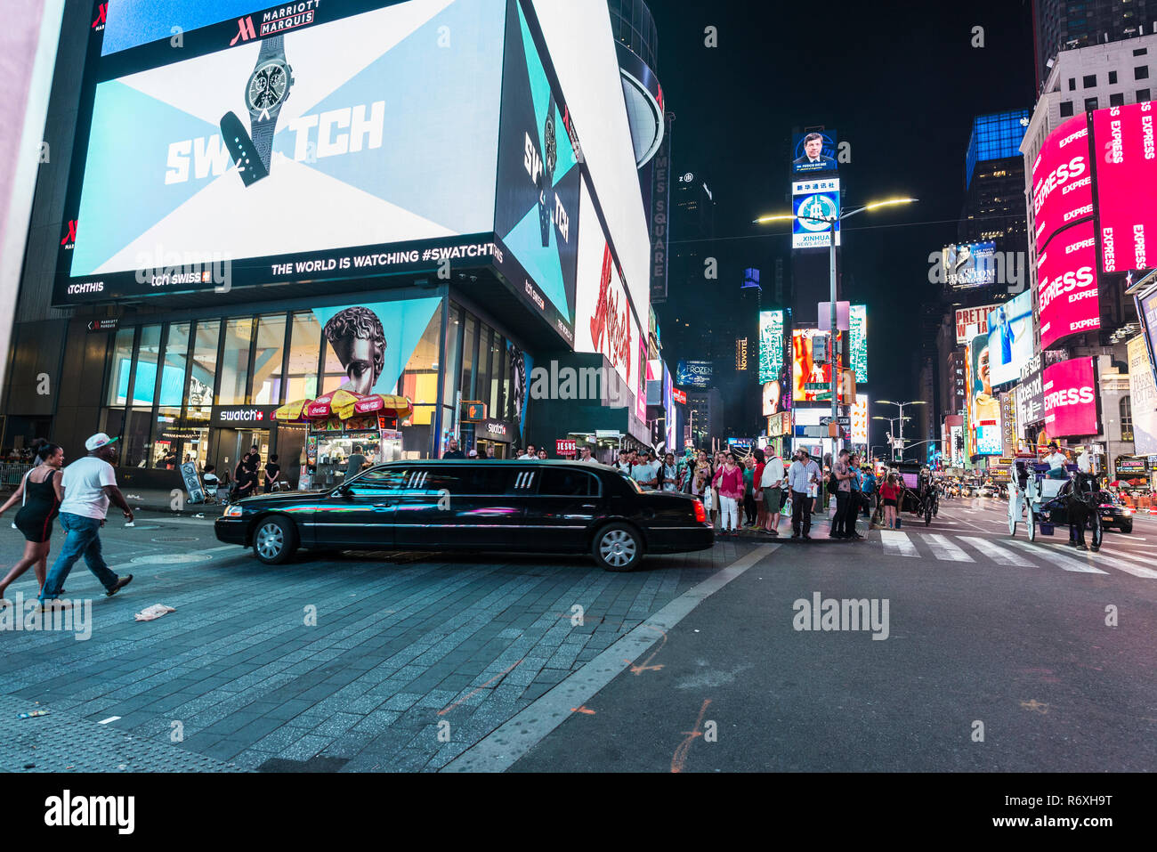 New York City, USA - 30. Juli 2018: Die schwarzen Luxuslimousine auf Times Square bei Nacht mit Menschen um und große Werbefenster in Manhattan in N Stockfoto