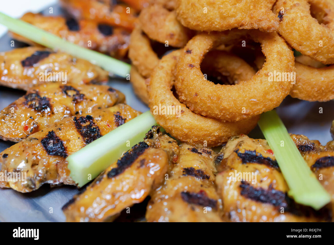 Platte der Flamme gegrillte Hähnchenflügel mit Zwiebelringen und Selleriestangen Zimmer für Kopie Stockfoto