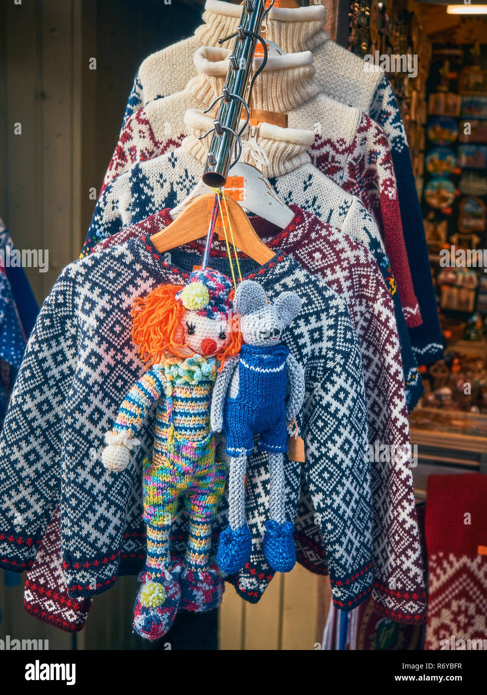 Auf der Straße in der Nähe des Shops gestrickte Pullover sind für Verkauf, und Merry gestricken Spielzeug für die Dekoration neben Ihnen verkauft werden. Stockfoto