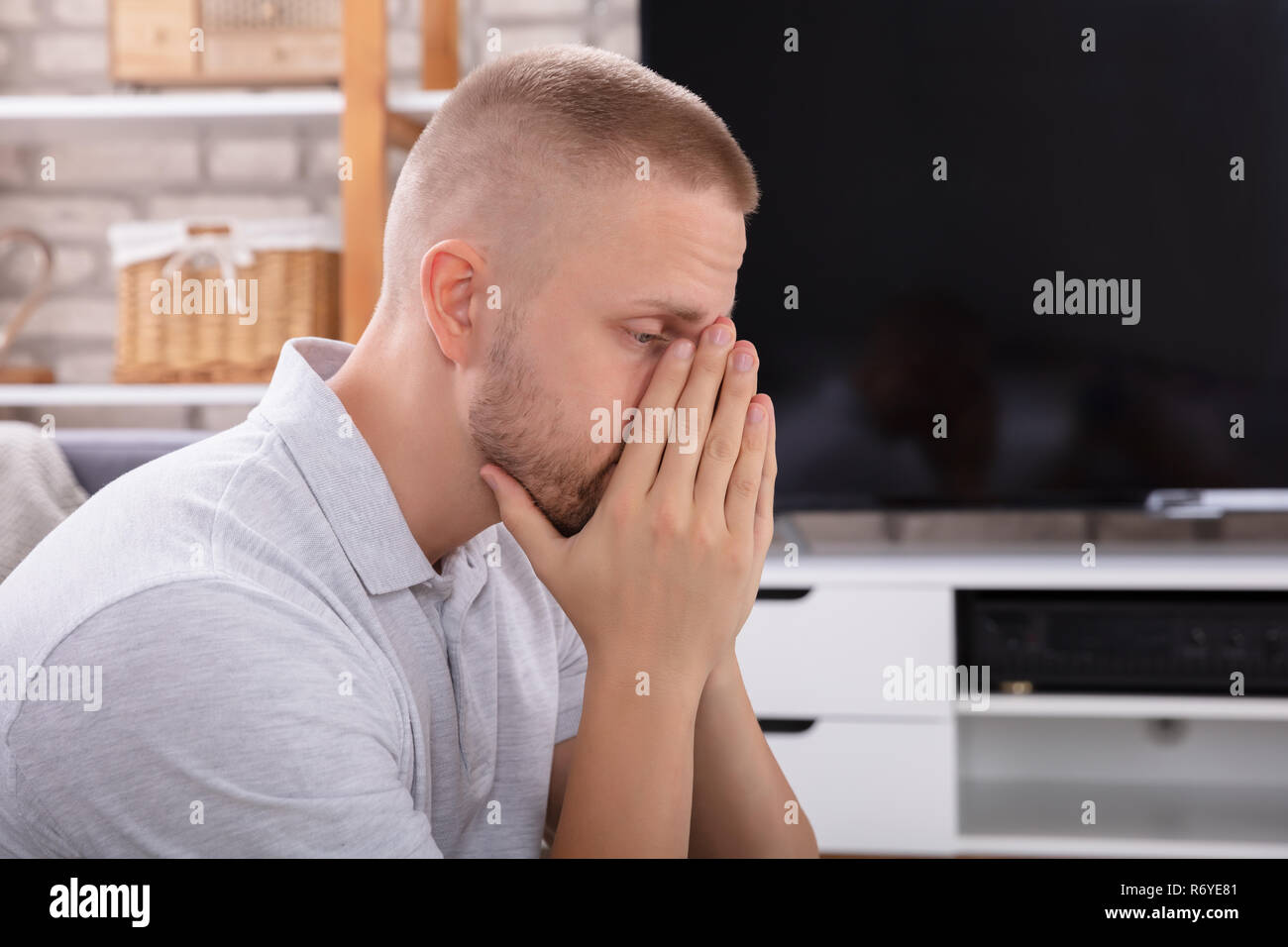 Seitenansicht eines umgekippten Junge Mann sitzt auf einem Sofa Stockfoto