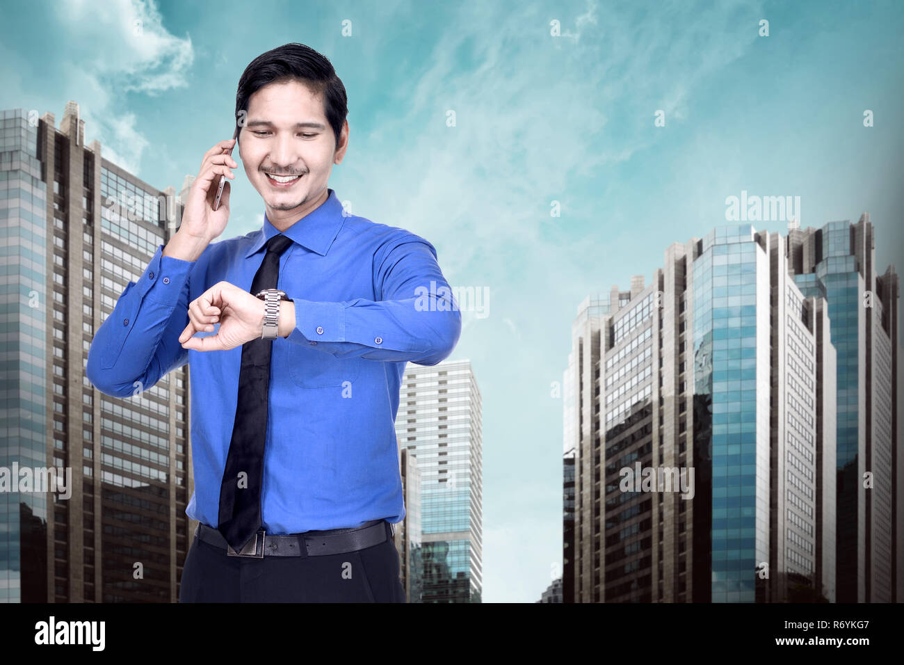 Schöne asiatische Geschäftsmann mit Phone und die Uhr prüfen Stockfoto