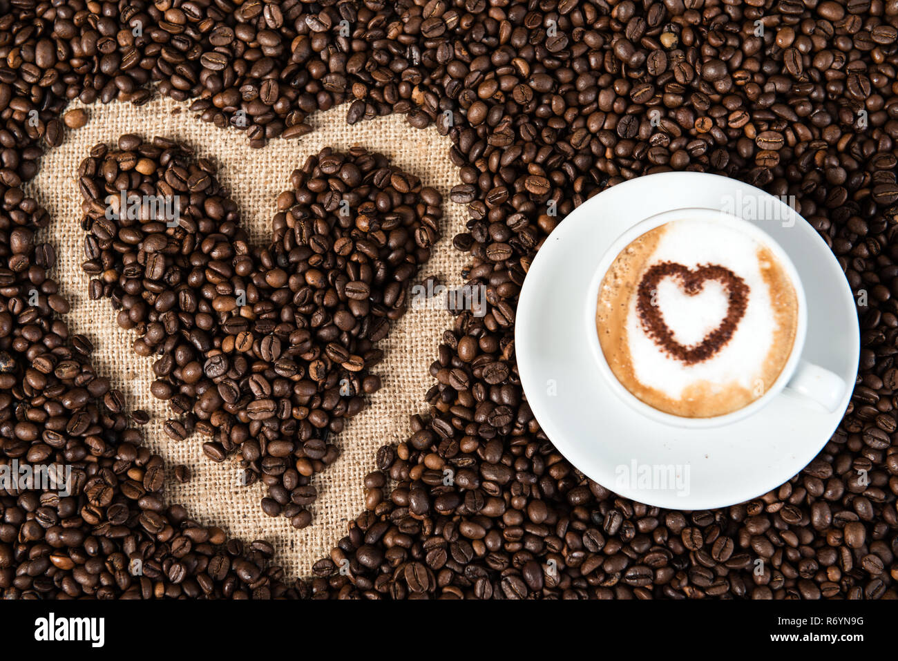 Cappuccino auf eine Menge Kaffee Bohnen Stockfoto