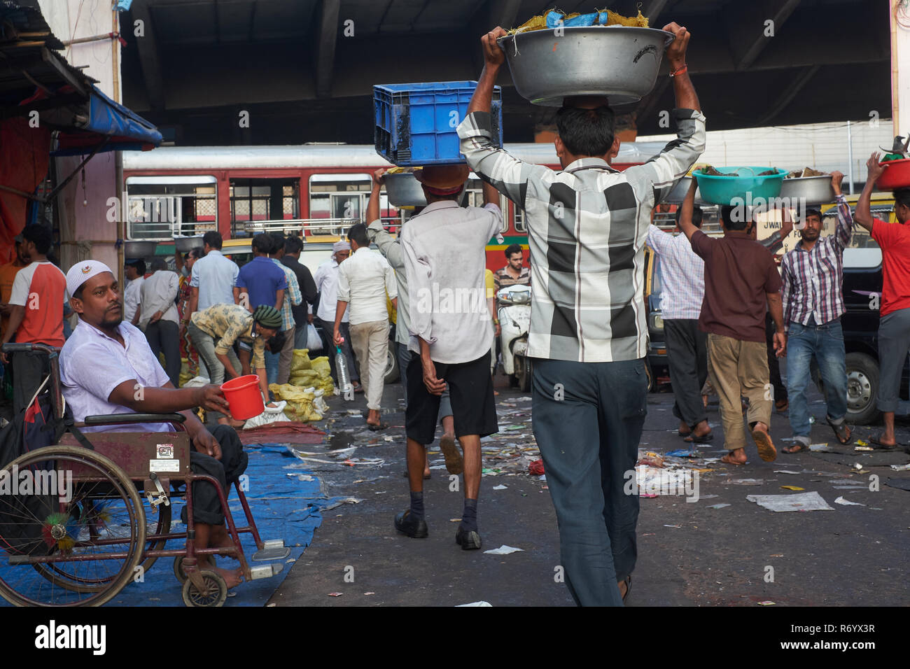 Ein Bettler und Torhüter in einem geschäftigen Fischmarkt in Mumbai, Indien Stockfoto
