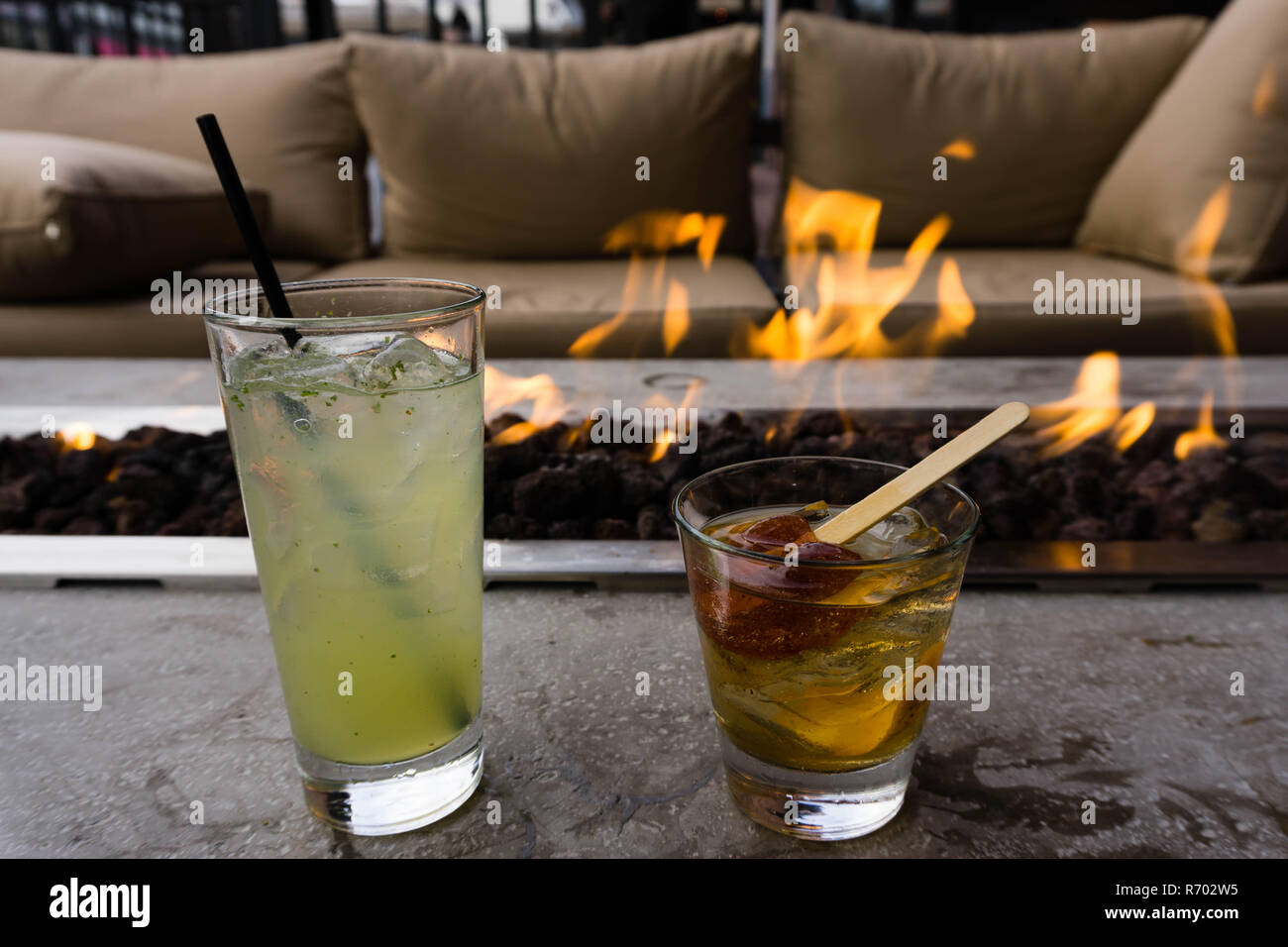 Genießen einige Fancy Drinks in der Nähe von einem Gas Feuerstelle ausserhalb in der Innenstadt von San Diego, Kalifornien Stockfoto