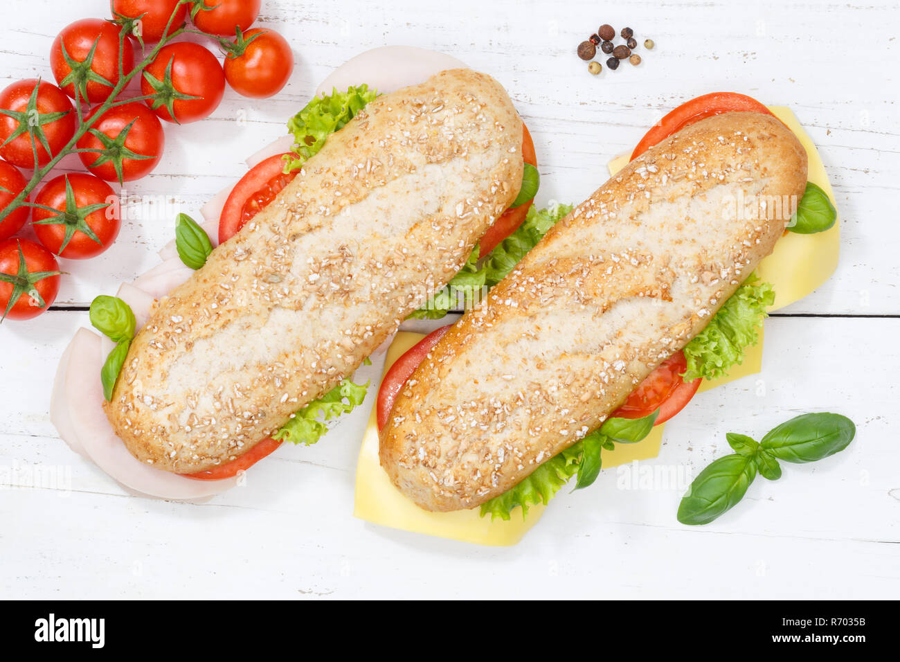 Sandwich baguette Vollkorn Brötchen mit Käse und Schinken von oben aufgefüllt auf Holzbrett Stockfoto