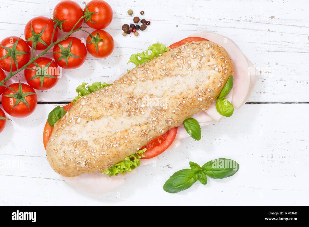 Sandwich baguette Vollkorn Brötchen mit Schinken von oben auf Holzbrett gekrönt Stockfoto