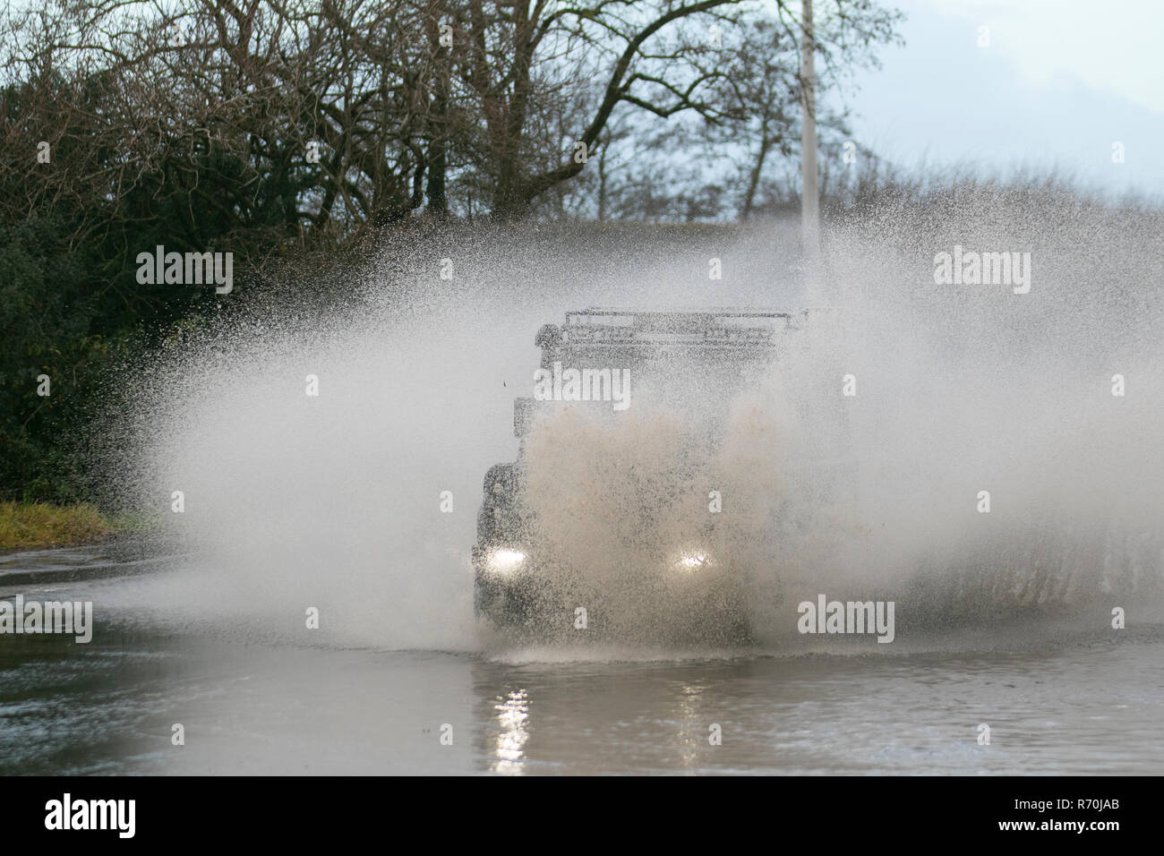 Auto fährt durch tiefes, schnell fließendes Wasser, überflutete Straße in Preston, Lancashire. Dez 2018. Wetter in Großbritannien: Land Rover, mit Schnorchelauspuff, fährt auf überfluteten Straßen, nachdem es über Nacht stark geregnet hat, was zu schwierigen und gefährlichen Fahrbedingungen führt. Quelle: MediaWorldImages/Alamy Live News Stockfoto