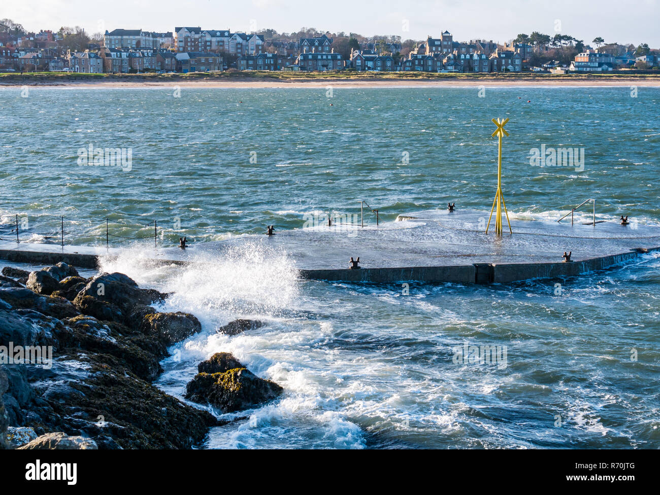 North Berwick, East Lothian, Schottland, Vereinigtes Königreich. 7. Dezember 2018. UK: ein helles, sonniges Wetter, aber sehr windigen Tag in der Stadt am Meer mit Böen von bis zu 60 km/h Vorhersage für heute. Wellen Spritzen auf dem Pier und den Felsen der Küste Stockfoto