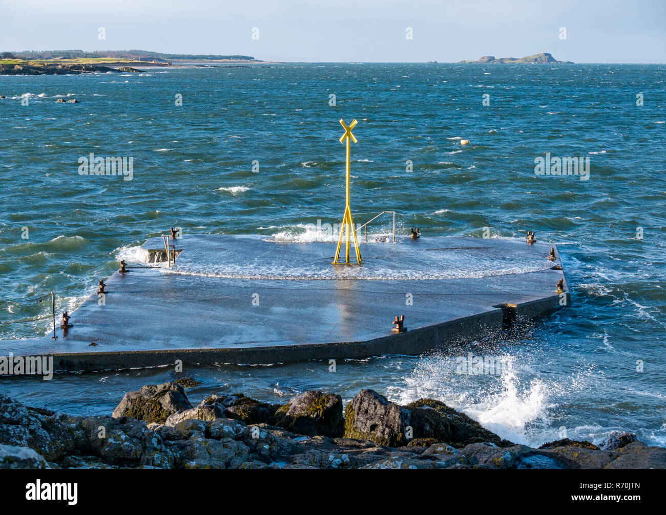 North Berwick, East Lothian, Schottland, Vereinigtes Königreich. 7. Dezember 2018. UK: ein helles, sonniges Wetter, aber sehr windigen Tag in der Stadt am Meer mit Böen von bis zu 60 km/h Vorhersage für heute. Wellen Spritzen auf dem Pier und den Felsen der Küste Stockfoto