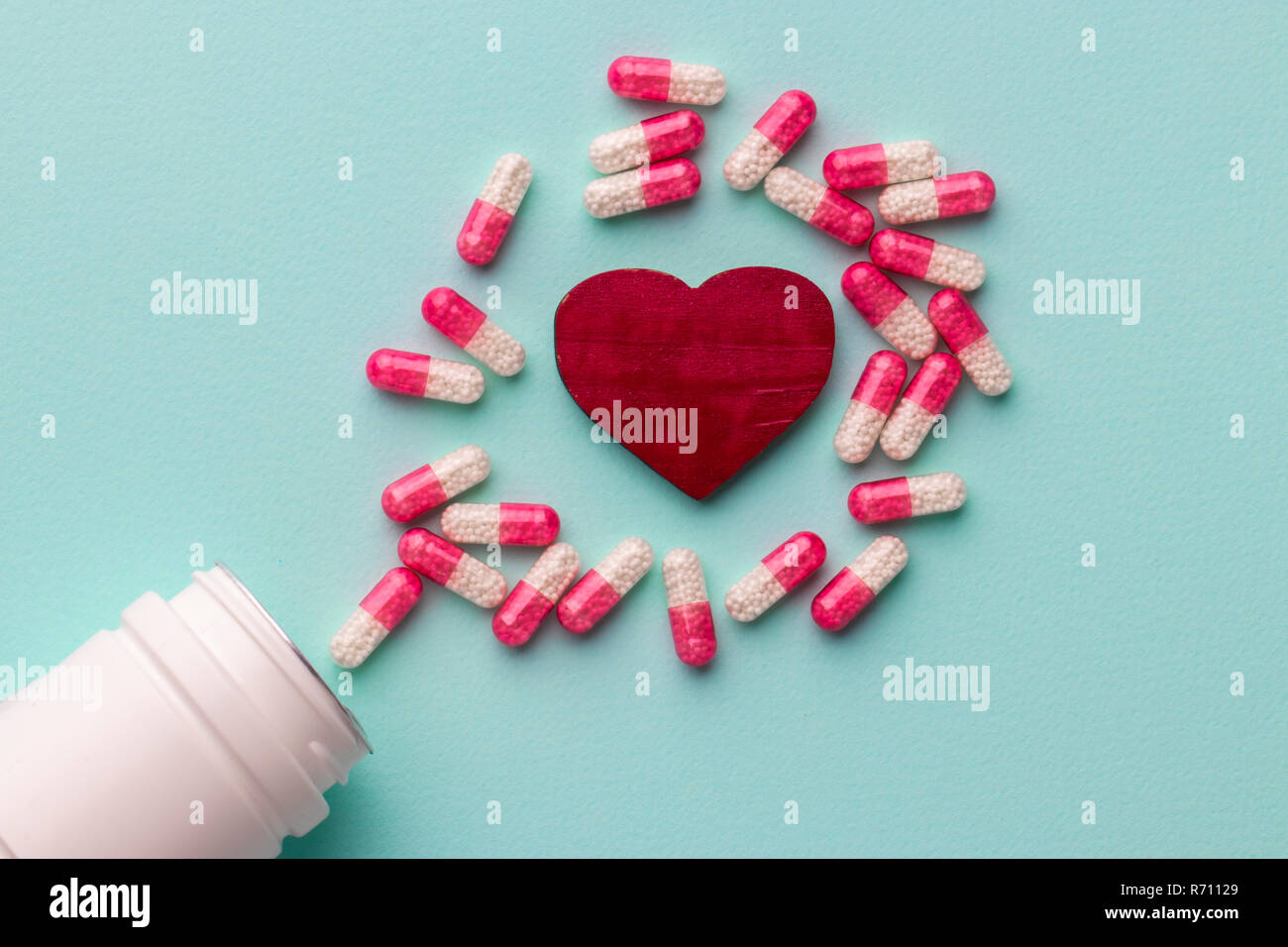 Rotes Herz mit Pillen auf Tisch Stockfoto