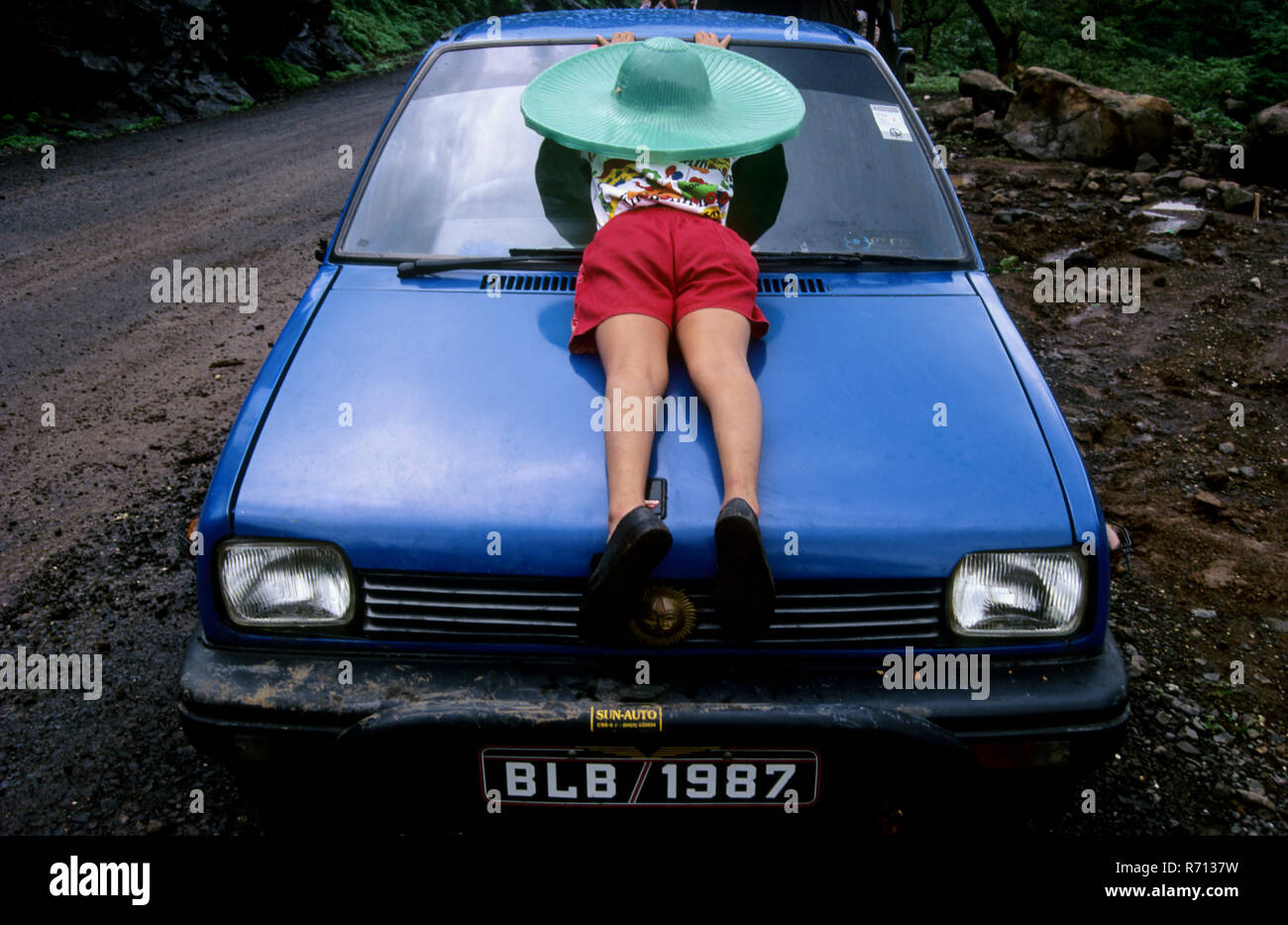 Eine seltene Betrachtungswinkel von Jungen schlafen auf der Motorhaube von maruti Auto Stockfoto