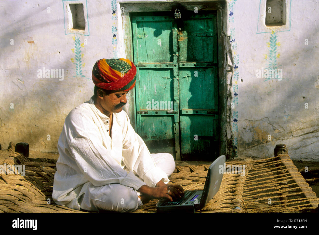 Rajasthani Mann betrieb Laptop außer Haus, Pushkar, Rajasthan, Indien Stockfoto