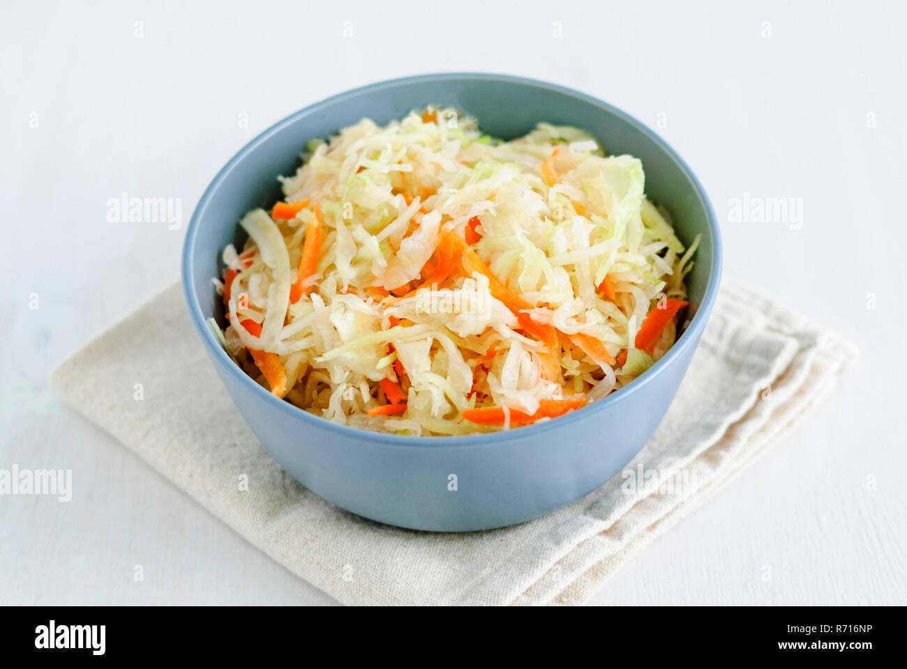Von oben geschossen von Schüssel mit leckerem Sauerkraut auf Stück Stoff auf weißem Hintergrund Stockfoto