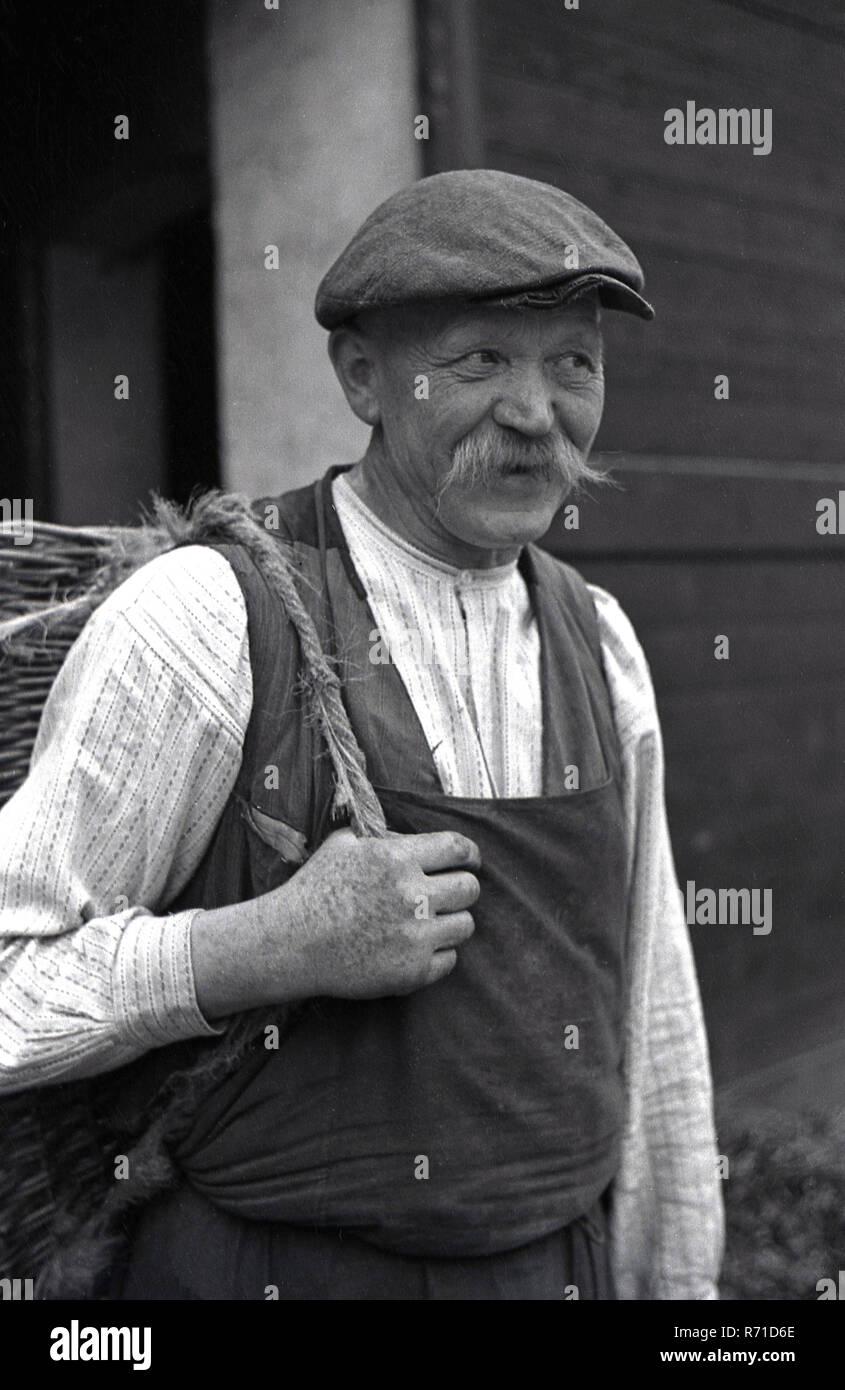 1930er Jahre, historische, vor dem Krieg, sudentenland, der Tschechoslowakei, das Porträt einer männlichen Landarbeiter seinen Korb tragen. Stockfoto