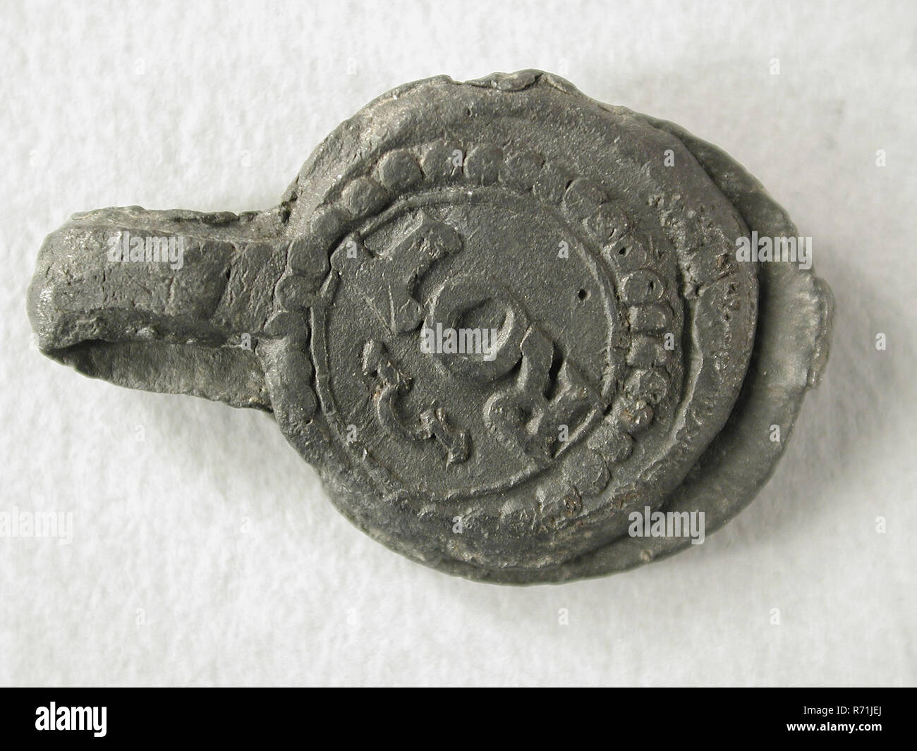 Tuch Dichtung aus Rotterdam mit Feuer Schlaganfall und Eigentum kennzeichnen, Tuch Dichtung hallmark Boden finden führen Metall, gegossen geschlagen Tuch führen von Rotterdam mit an der Front in Perle rand rot und Feuer Anschlag und auf der Rückseite in Pearl edge Eigentum kennzeichnen oder private Label mit 4 und langen Bein und Initialen und Geschlossen, ROT Archäologie Rotterdam Authentifizierung Regierung Handel mit Textilwaren Textilwaren Handel Handel Gilde Stockfoto