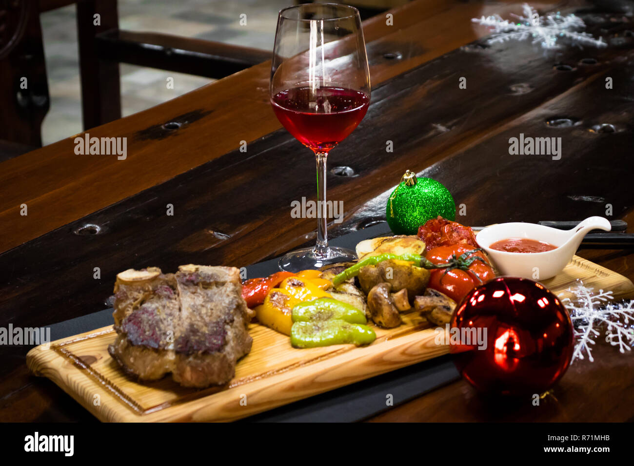 Rindersteak und Wein auf dem hölzernen Tisch in der Kneipe Stockfoto