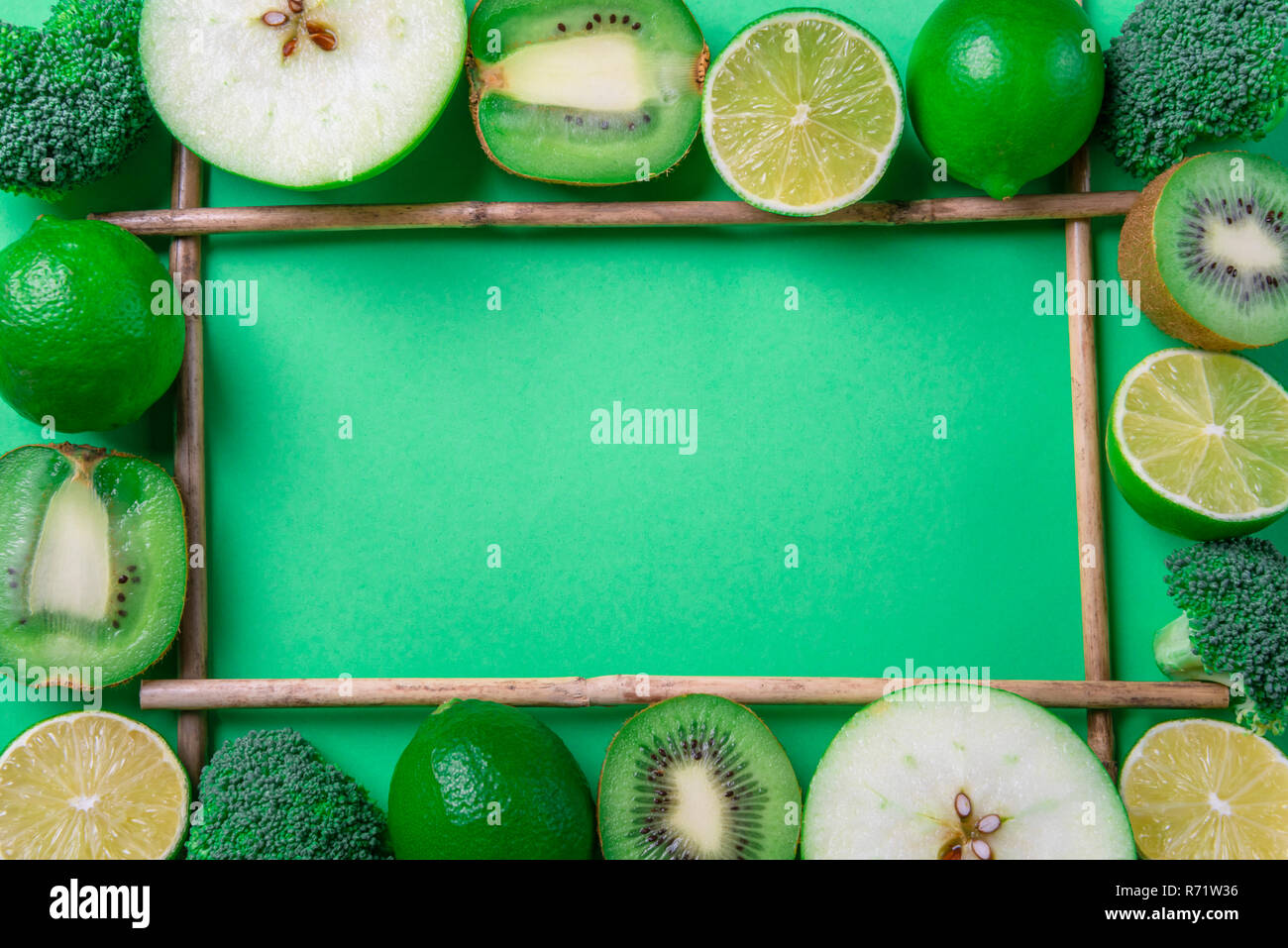 Oben Blick auf einen Rahmen aus frischen, grünen Früchte und Brokkoli, am grünen Tisch. Das gesunde Essen. Detox Kontext. Diät essen. Vegetarische Nahrungsmittel Stockfoto