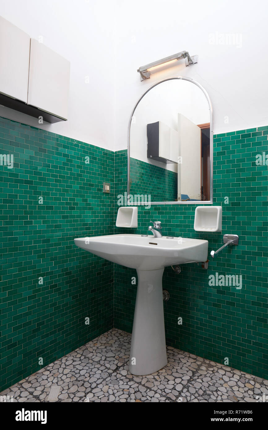 Waschbecken und Spiegel in grün gefliesten Badezimmer, alte Wohnung Interieur Stockfoto