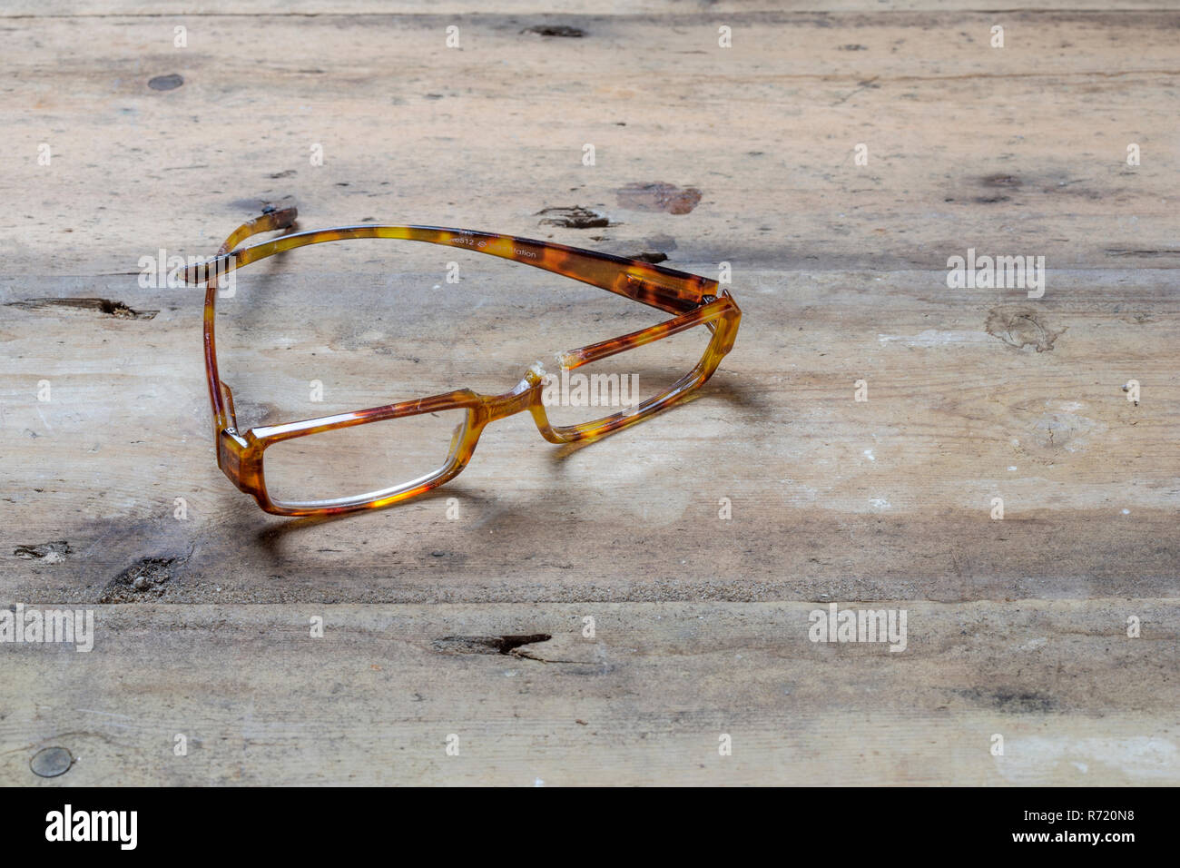 Gebrochene schildpatt Brille auf einer rauhen Holz- Oberfläche Stockfoto