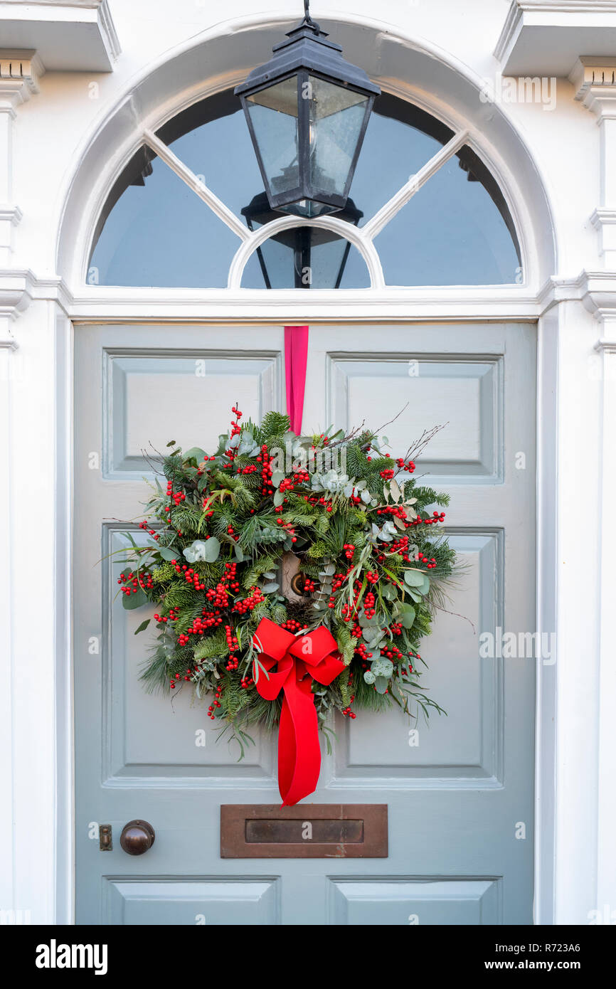 Weihnachtskranz mit einem roten Band an einer Haustür am Broadway.  Cotswolds, Worcestershire, England Stockfotografie - Alamy