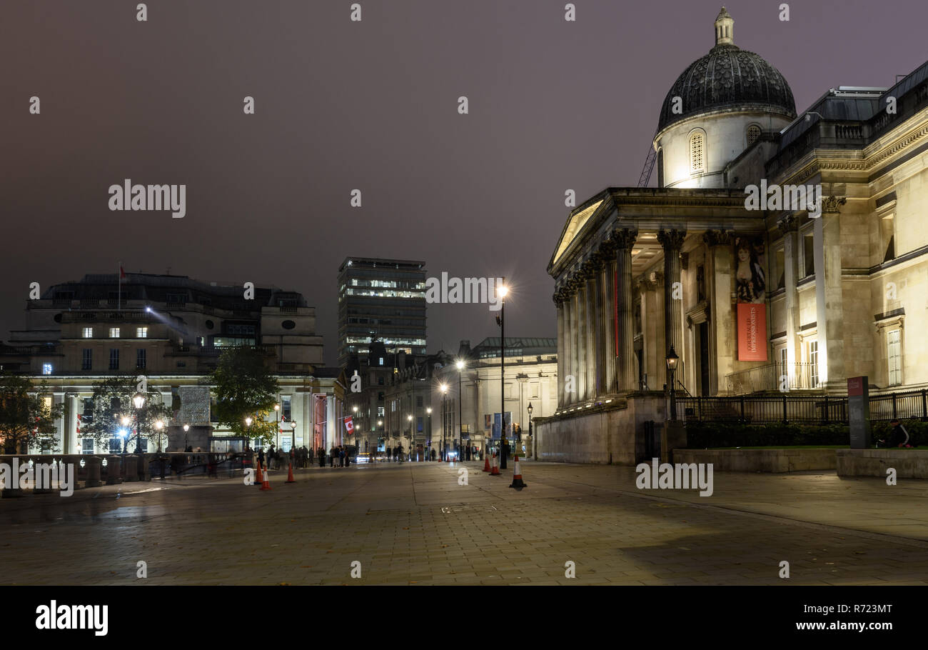 London, England, UK - 15. Oktober 2018: Fußgänger auf dem Londoner Trafalgar Square bei Nacht, alingside der National Gallery und Kanada Haus, Stockfoto