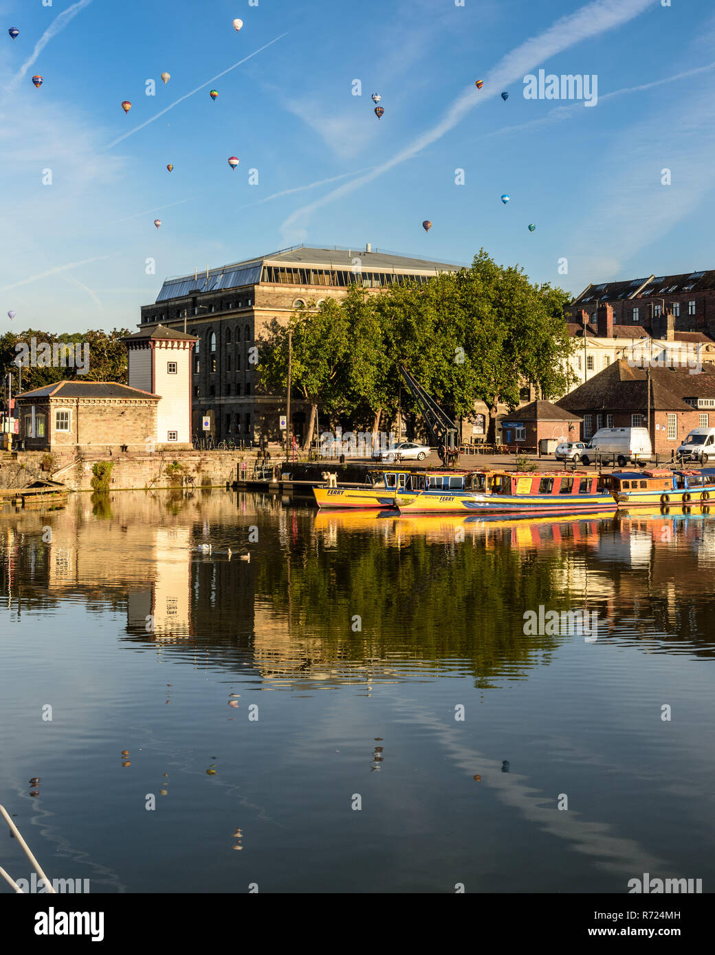 Bristol, England, Großbritannien - 11 August 2018: Heißluftballons schweben über dem Stadtbild von Bristol, einschließlich der Arnolfini Art Gallery und der Stadt ico Stockfoto