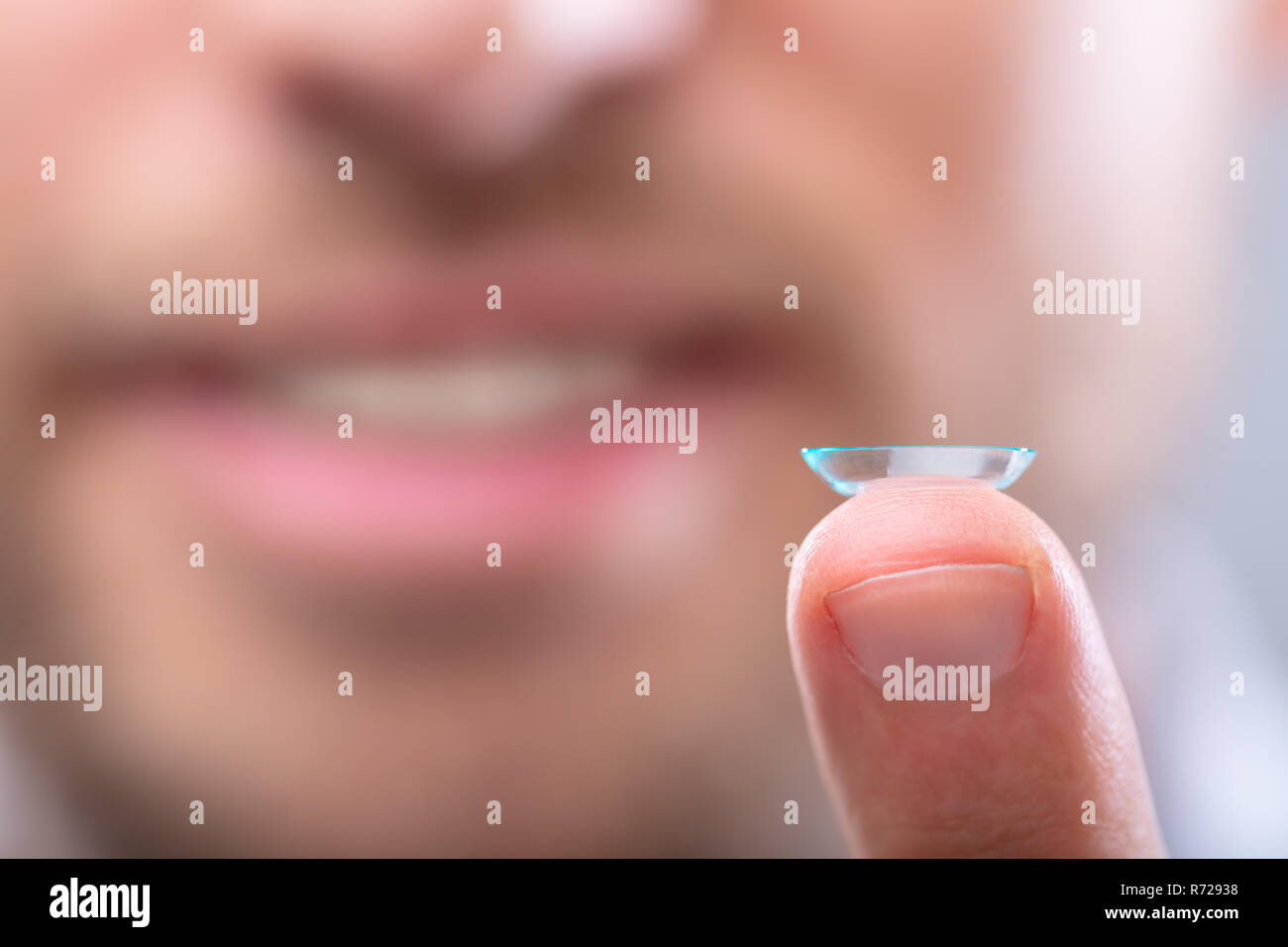 Close-up In eines Mannes Finger mit transparenter Linse Stockfoto