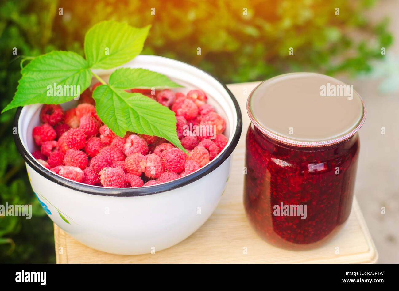 Banken mit duftenden hausgemachte Himbeermarmelade im Garten. Im Sommer Ernte. süße Speisen. Lebensmittel Vorrat für den Winter. Landschaft Natur, Outdoor. Stockfoto