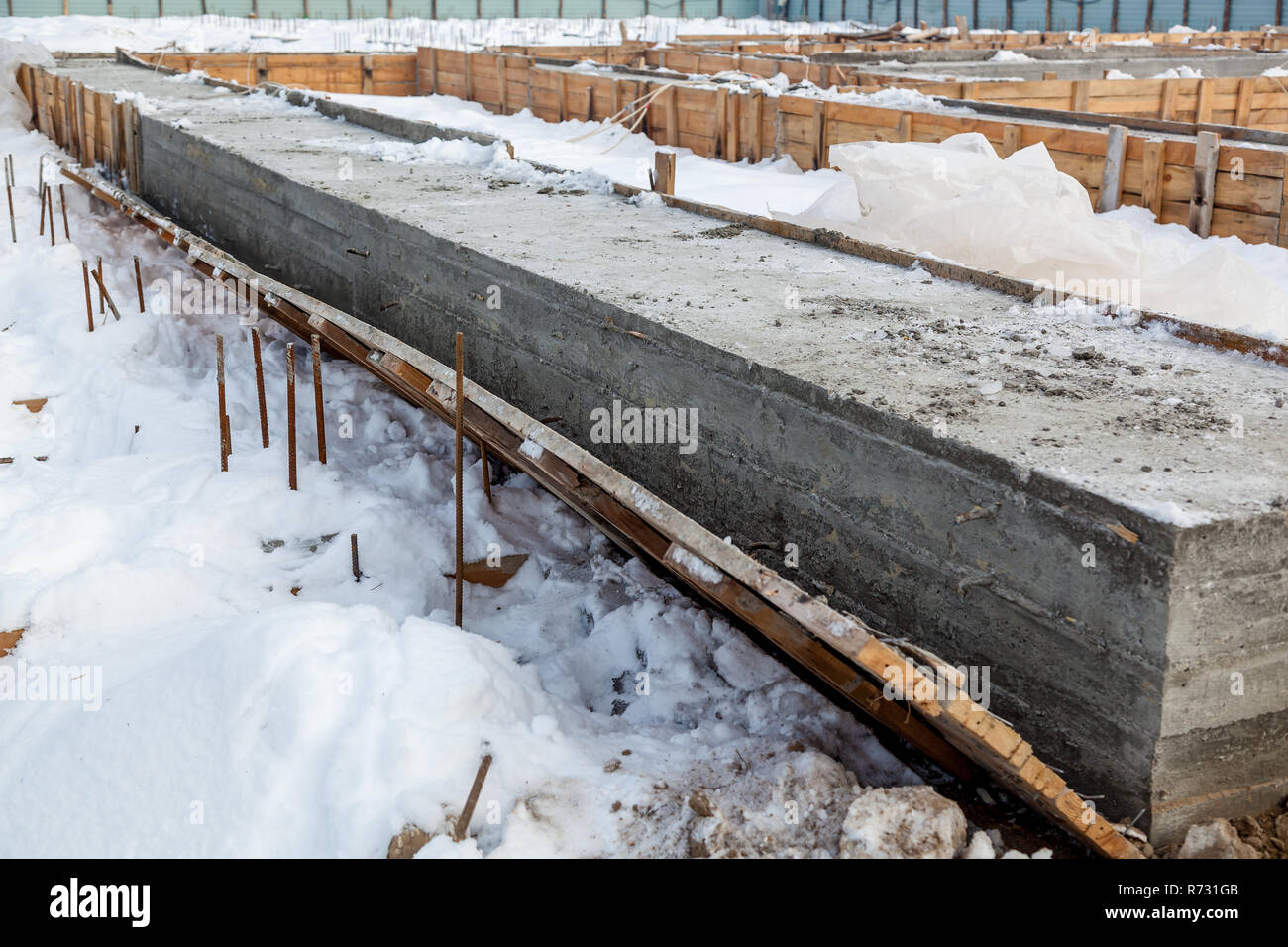 Betonfundament, Pfähle und Metallbau auf der Baustelle eines neuen Hauses. Der Prozess der ein Haus zu bauen, in der Anfangsphase. Stockfoto