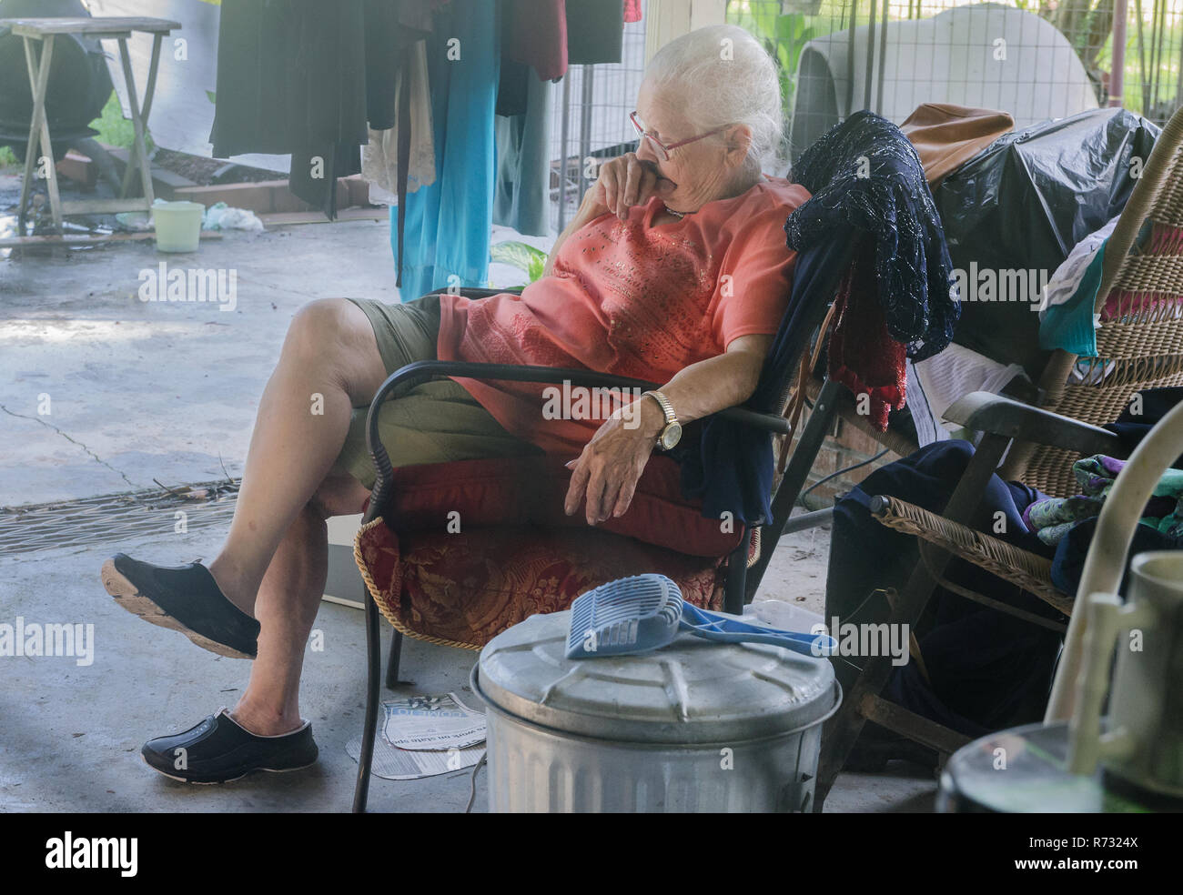 Eine ältere Flut Opfer beruht auf ihrer Terrasse als Freiwillige reinigen Sie ihren überschwemmten Haus, 22.08.2016, in Baton Rouge, Louisiana. Stockfoto