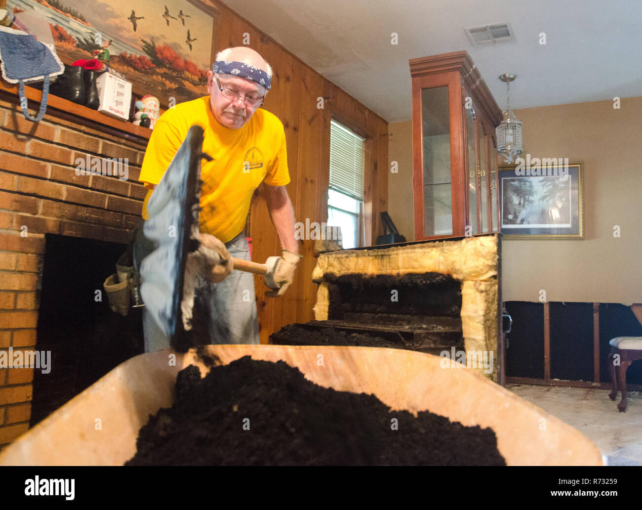 A Southern Baptist Katastrophenhilfe freiwillige Schaufeln Ruß aus einem Kamin nach einem Hochwasser in Baton Rouge, Louisiana. Stockfoto