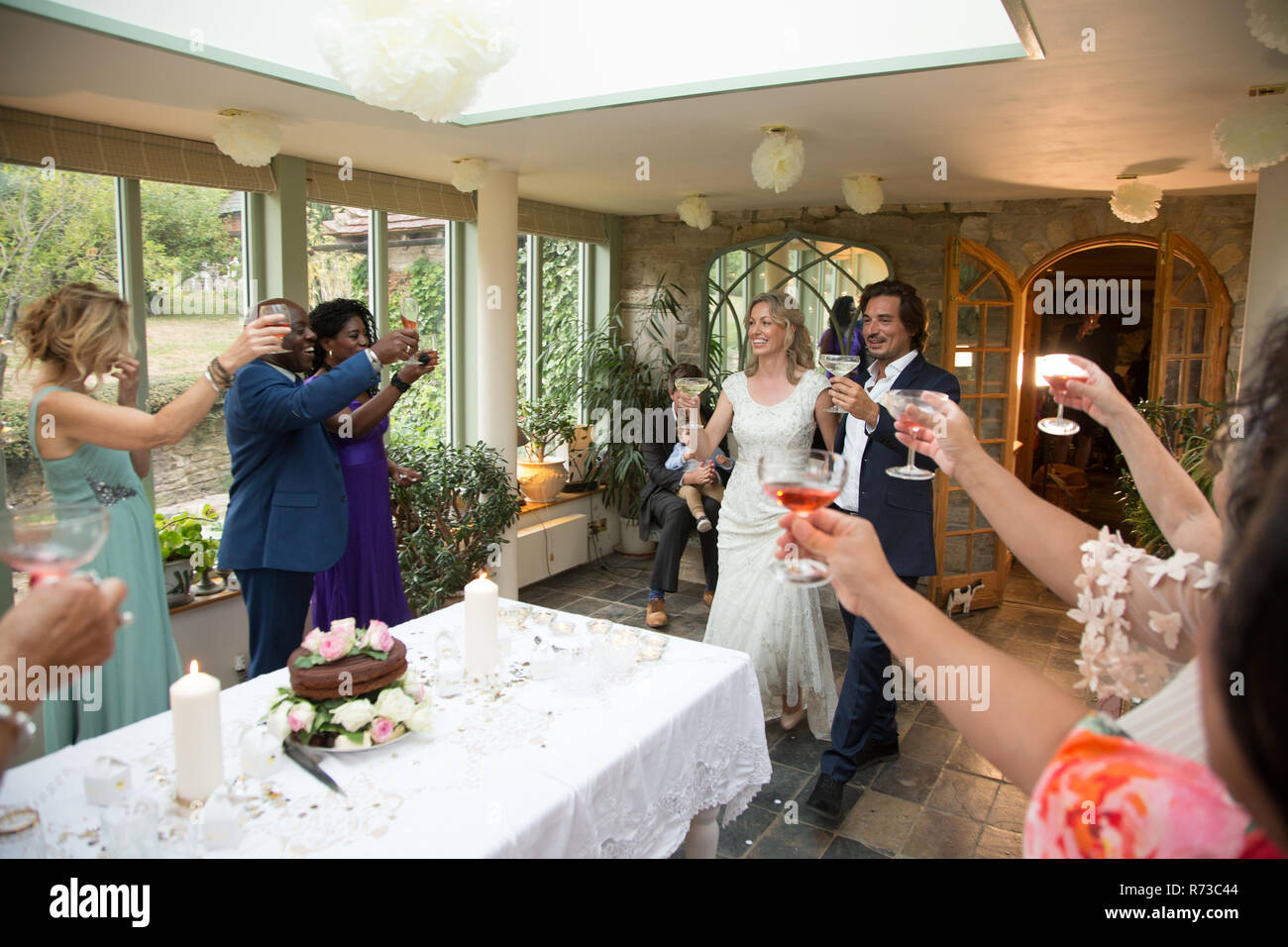 Hochzeitsgäste toasten, Jungvermählten an der Rezeption Stockfoto