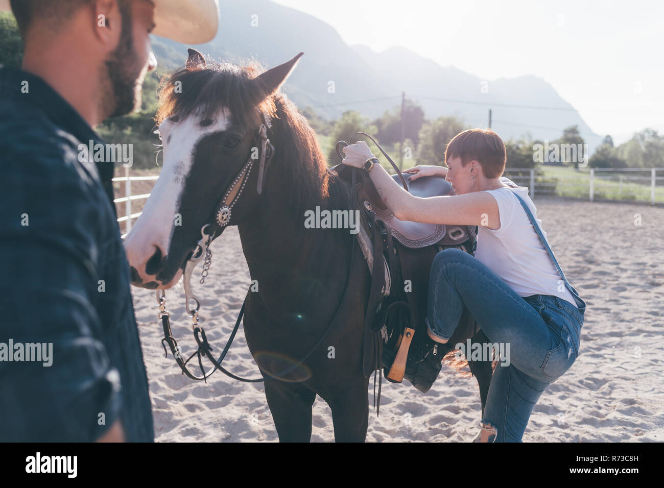 Junge Frau Montage Pferd in ländlichen Pferdesport Arena Stockfoto