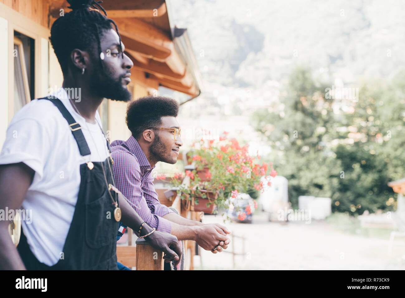 Zwei coole junge Männer in Log cabin Veranda, Primaluna, Trentino-Südtirol, Italien Stockfoto