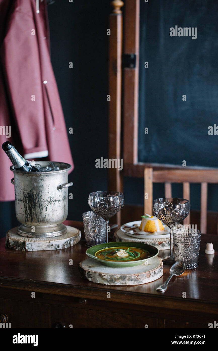 Schale mit frischem garniert Suppe, Nachtisch und Champagner auf vintage Tabelle Stockfoto