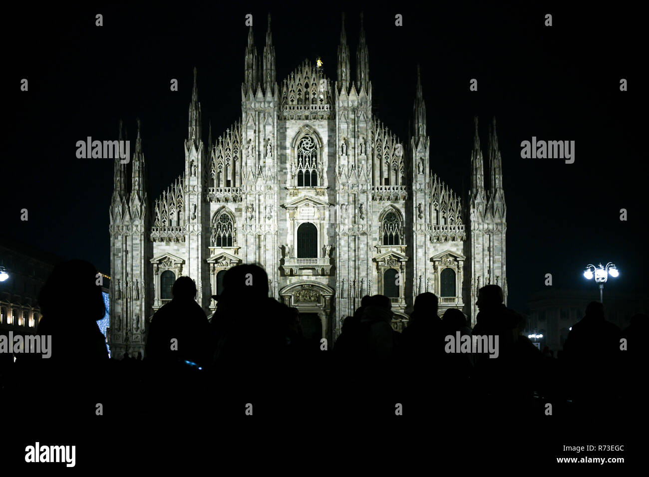 Weihnachten in Mailand, Italien. Silhouette von Menschen vor dem Dom Fassade bei Nacht beleuchtet. Stockfoto
