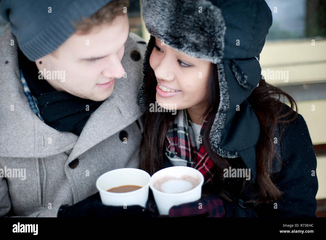 Junges Paar im Winter Hüte in Getränke zum Mitnehmen Stockfoto